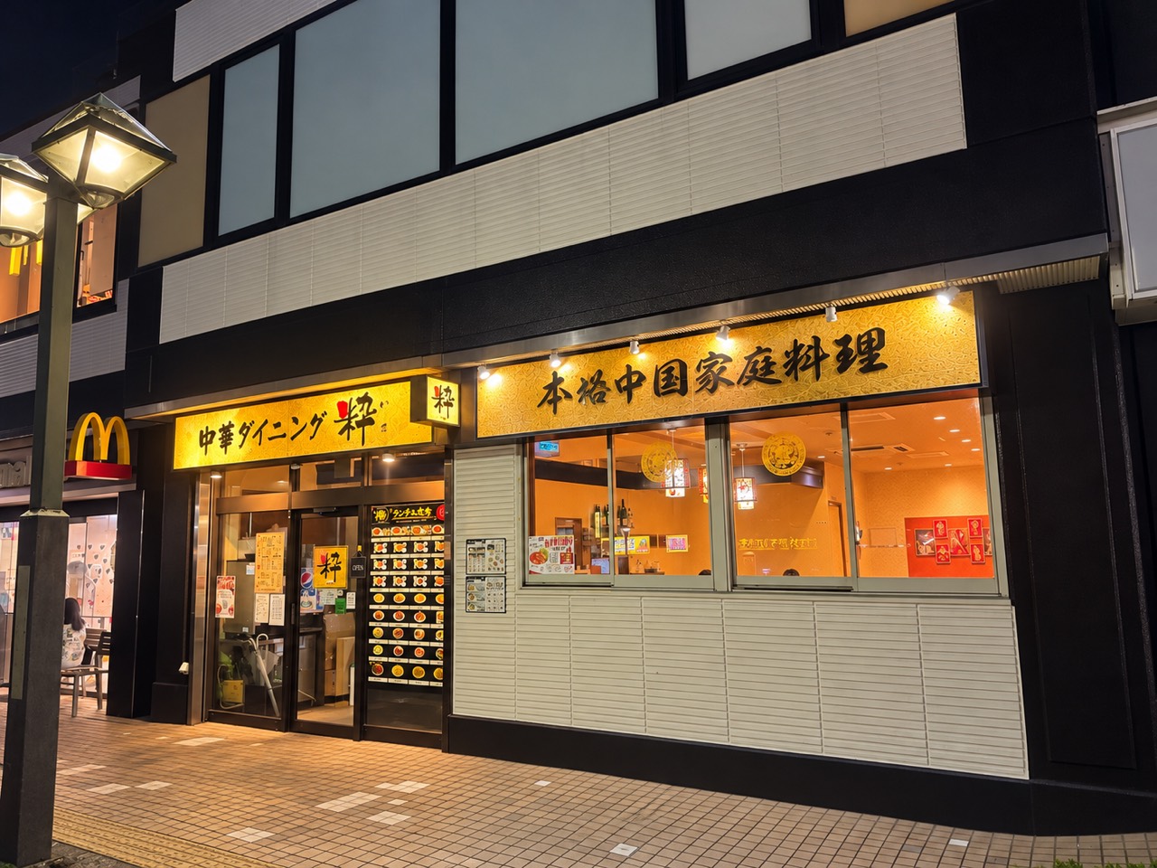 夜の中華ダイニング粋の外観。温かな明かりに照らされた店舗入口と看板。
